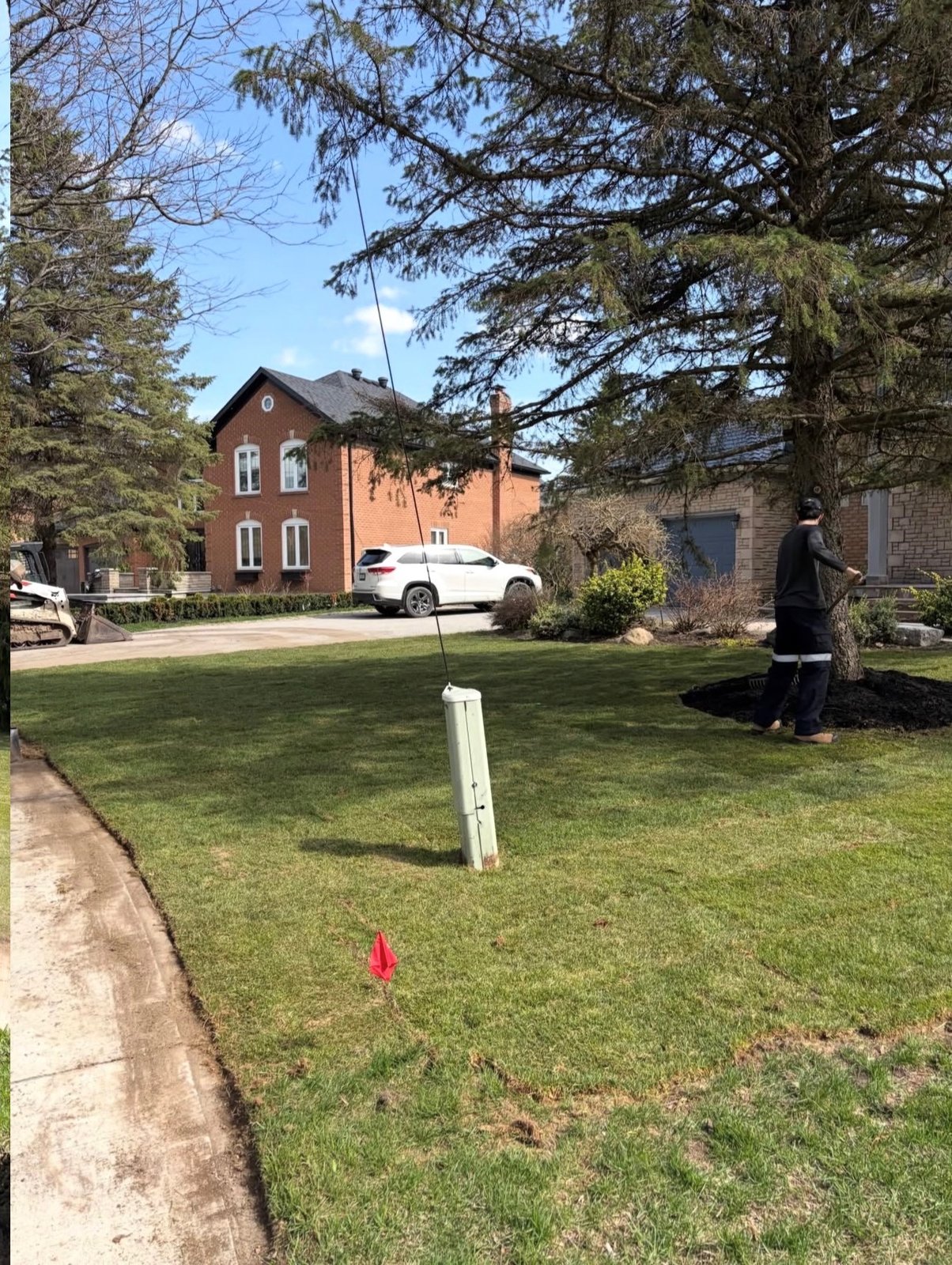 OSS Lawn Care team member working on a front-yard landscape